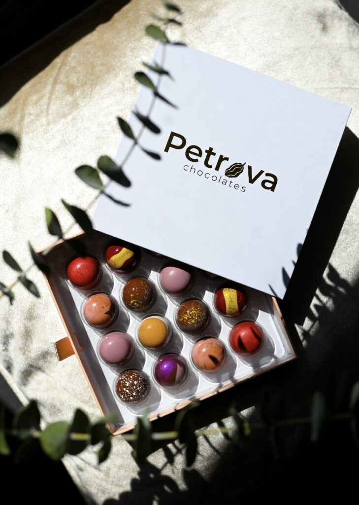 Colorful gourmet chocolates in a white box labeled Petrova 